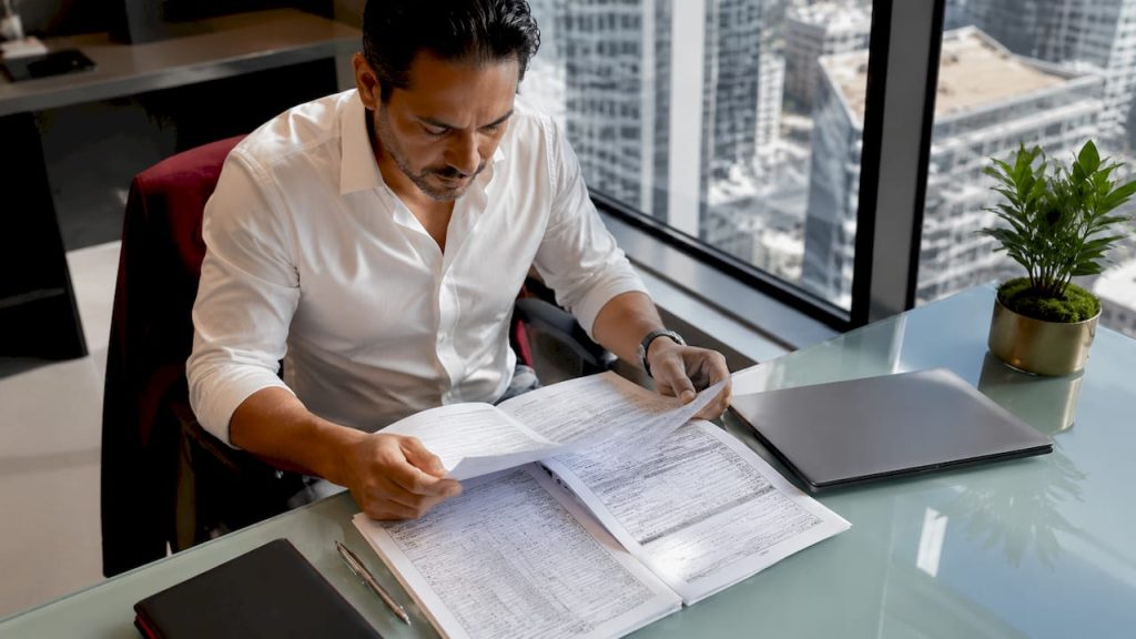 Businessman reviewing tax documents at desk