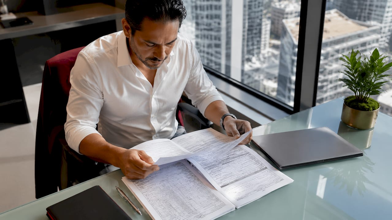 Businessman reviewing tax documents at desk