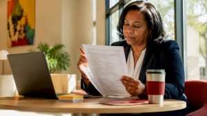Woman reviewing IRS Form 990 paperwork at desk